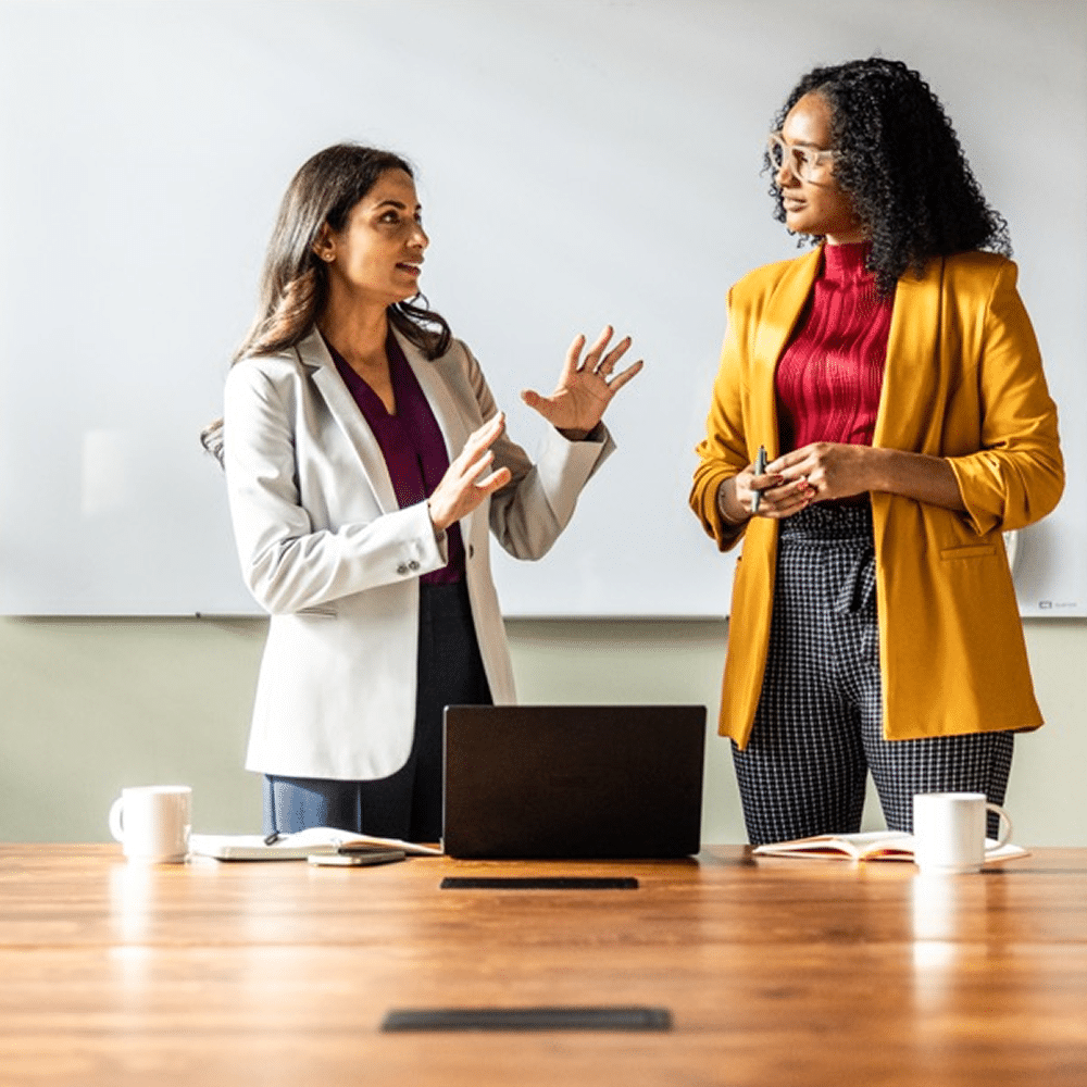 Two professionals presenting during a meeting.